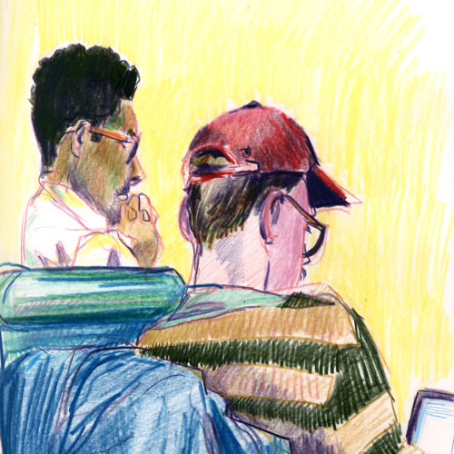 Two people are sitting side by side. One, wearing glasses and a short-sleeved shirt, appears focused on a screen. The other, in a red cap and striped shirt, looks at a device. The background is bright yellow, enhancing their outlines.